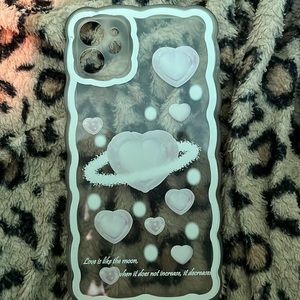 A clear iPhone 11 case with hearts on it